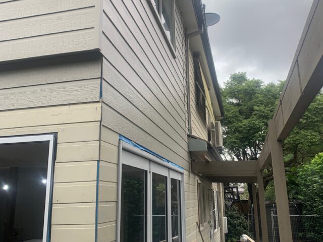 Two-storey weatherboard home renovation with new sliding doors, timber deck and pergola frame.