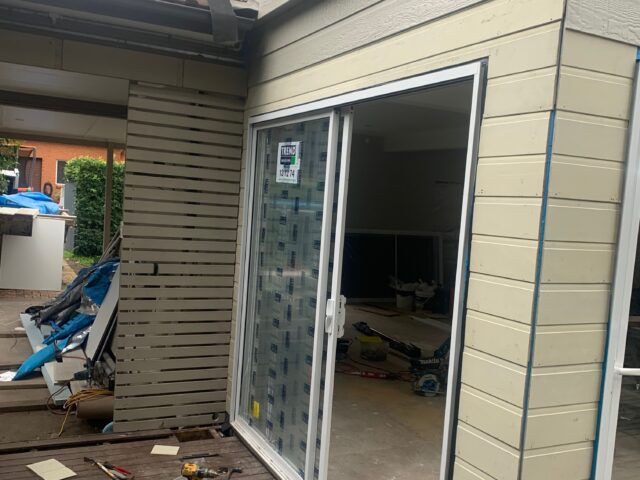 Home renovation: new sliding door fitted, timber deck and cladding underway.