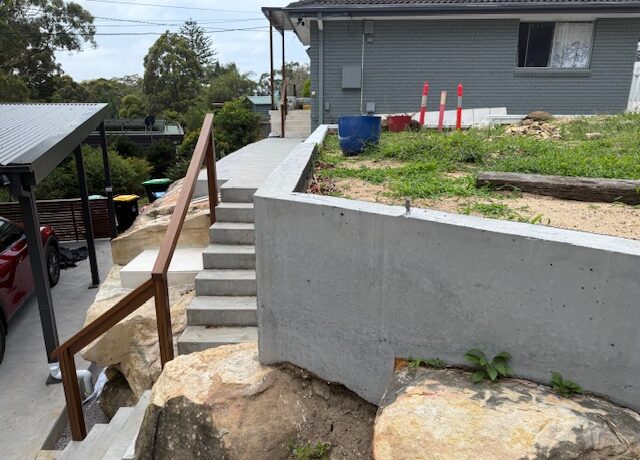 New concrete steps, retaining wall and handrail improving access on a sloping block.