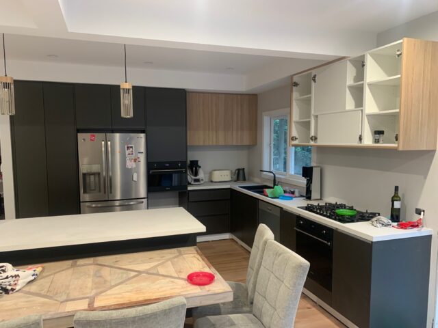 Modern kitchen renovation with two-tone cabinetry, open upper cupboards, island bench, pendant lights, and gas cooktop.