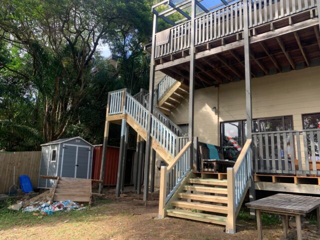 Multi-level timber deck with new stairs, balustrades and pergola frame during backyard renovation.